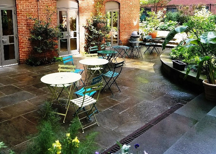 Photo of an outdoor patio area with some greenery around.